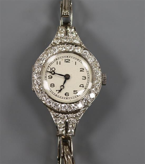 A ladys diamond set platinum cocktail watch on an 18ct gold bracelet.